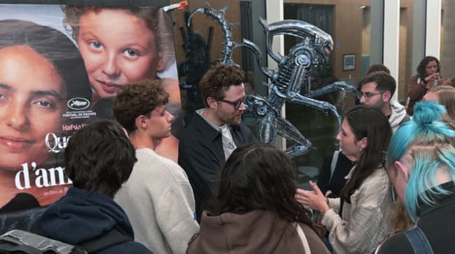 Rudi Rosenberg échange avec les étudiants d’EICAR devant l’affiche de Quelques mots d’amour